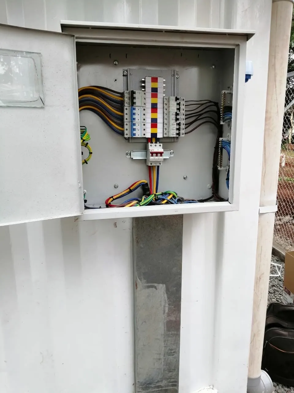 Wall-mounted board: Distribution board with colour-coded phase wiring.