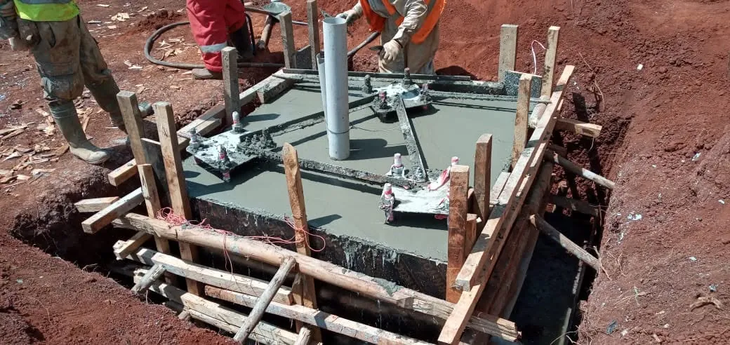 Foundation formwork: Concrete foundation with anchor bolts being poured.