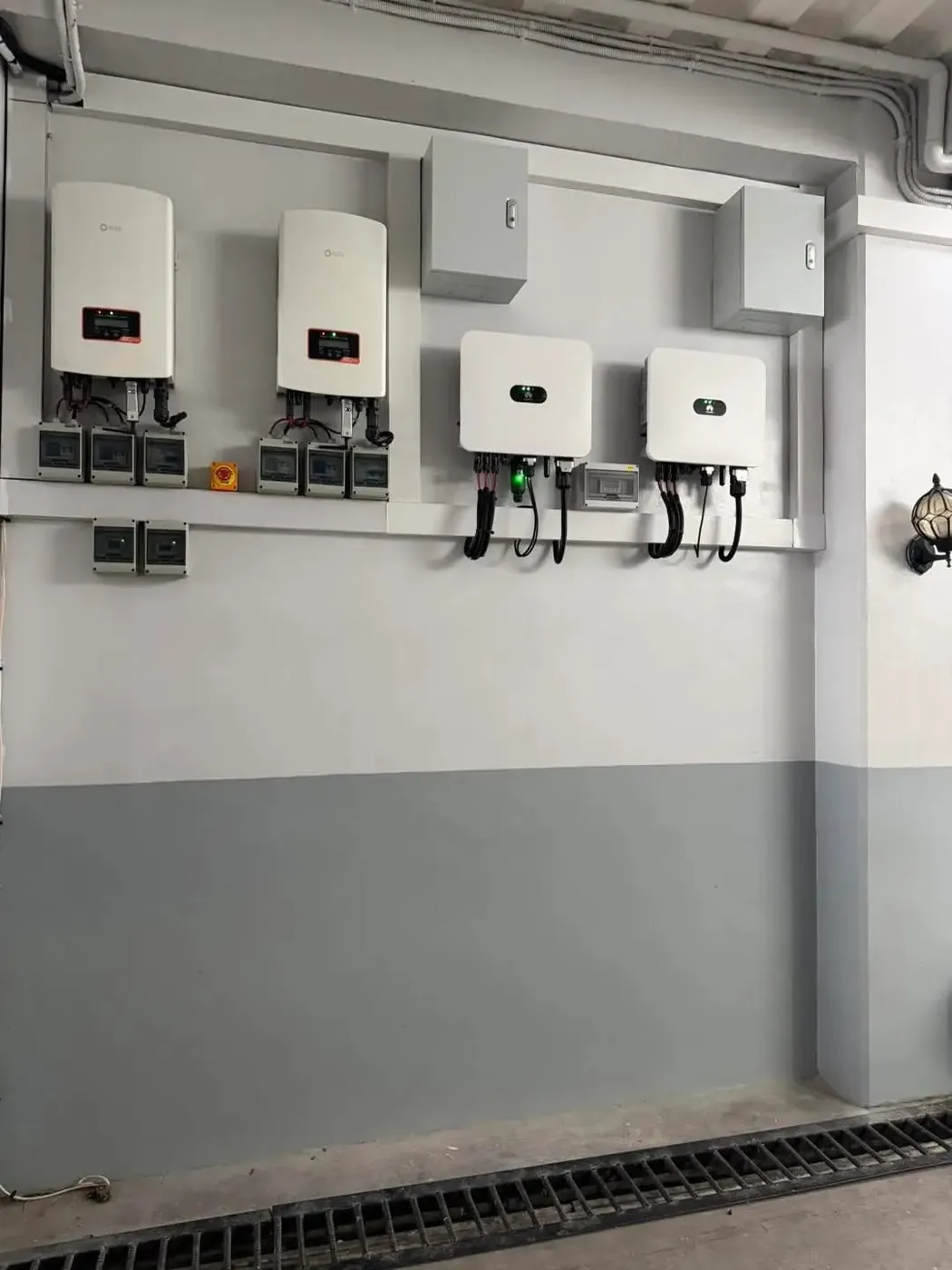 Solar inverters and isolators neatly mounted and wired on a plant room wall