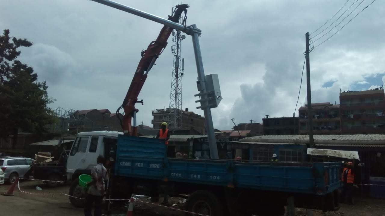 Crane lifting a power pole into position for last-mile connectivity works